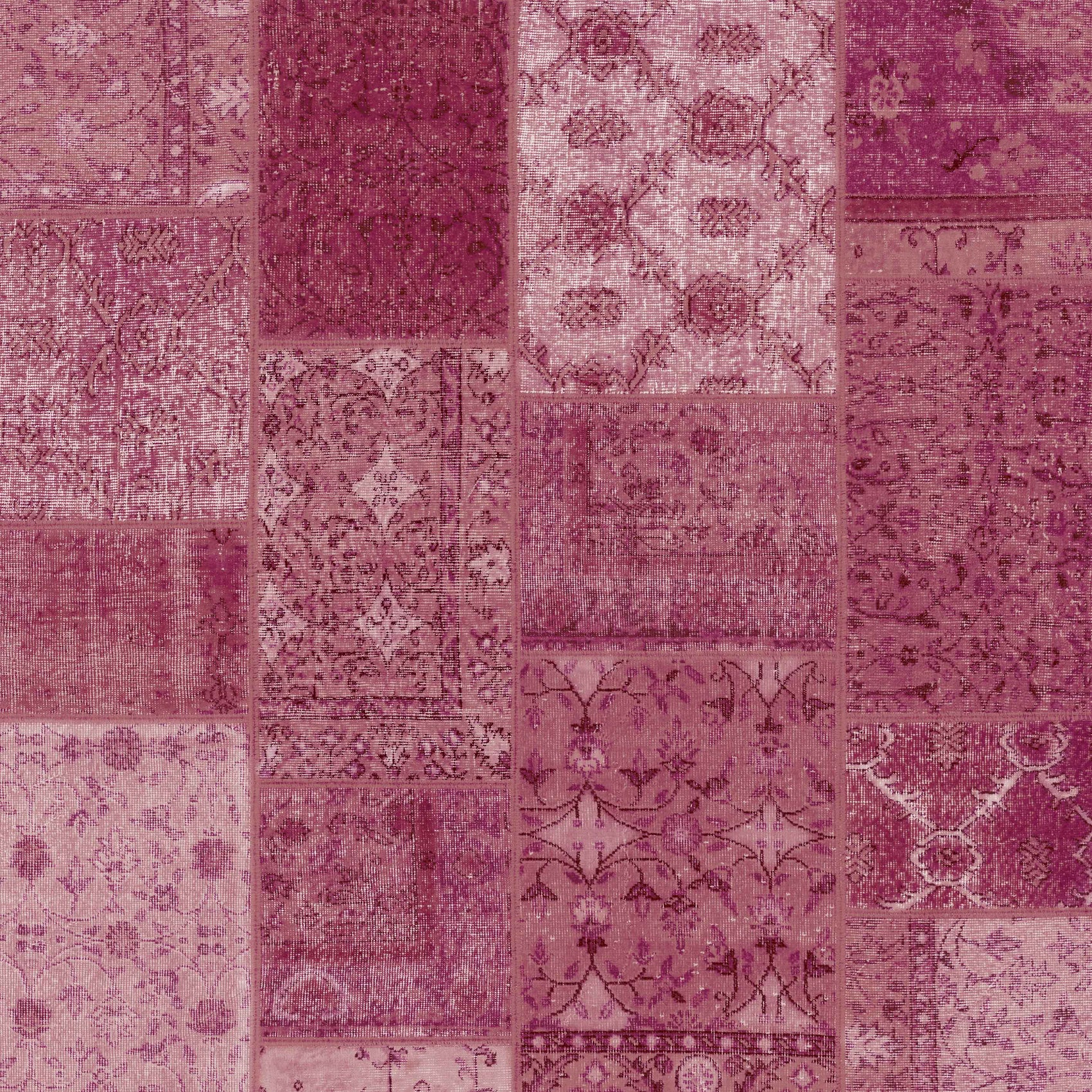 Patchwork pattern rug with various shades of purple and pink.