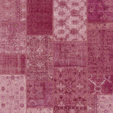 Patchwork pattern rug with various shades of purple and pink.