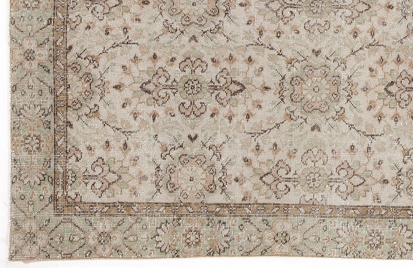 Beige, sage green, and brown traditional rug with a distressed floral medallion pattern and a decorative border.