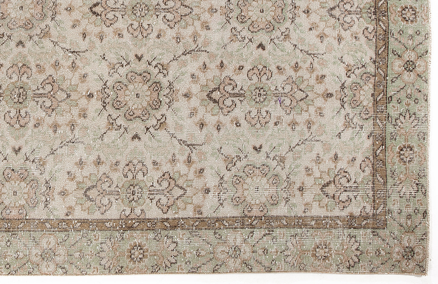Beige and sage green rug with a distressed traditional floral medallion pattern and a decorative border.