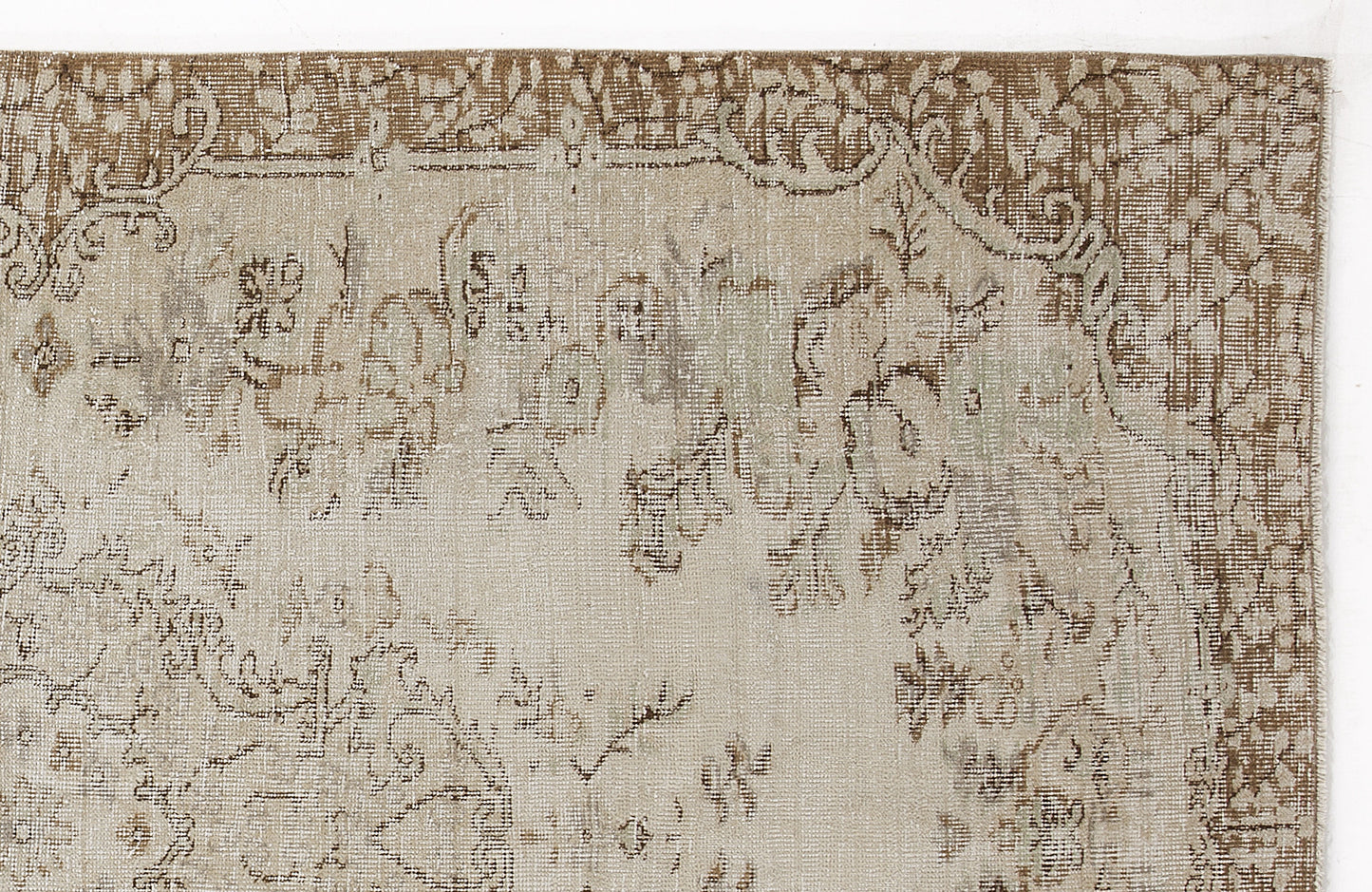 Beige and brown distressed rug with a faded traditional floral medallion pattern on a white background.