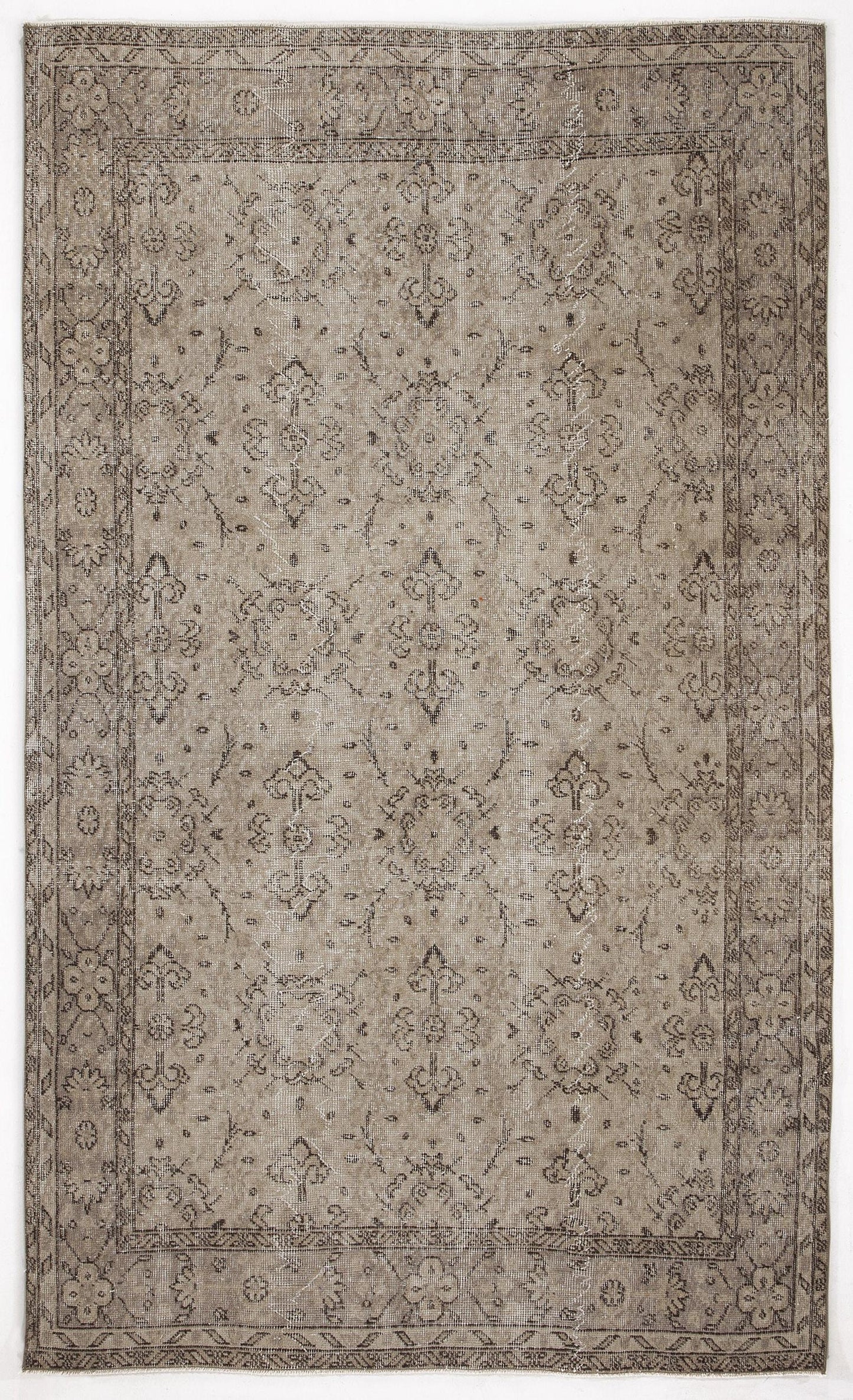 Taupe and charcoal distressed rug with a traditional floral medallion pattern and a decorative border.