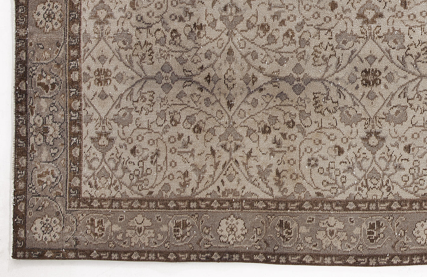 Taupe and brown traditional rug with a distressed floral vine pattern and a detailed geometric border.