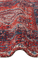 A close-up of the Heritage Blend - Washable Kilims - AND02 rug showcases its red and blue intricate patterns, visible texture, and a gentle wave along the surface.