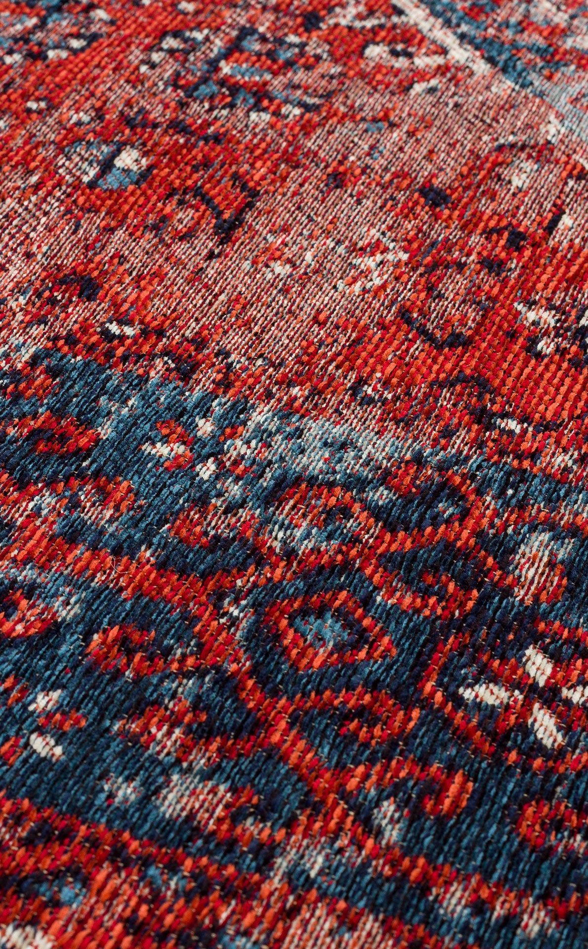 Close-up of the Heritage Blend - Washable Kilims - AND02, showcasing intricate red, blue, and white motifs on a textured woven surface. This washable kilim offers a slightly distressed look—an ideal choice for allergy-conscious spaces