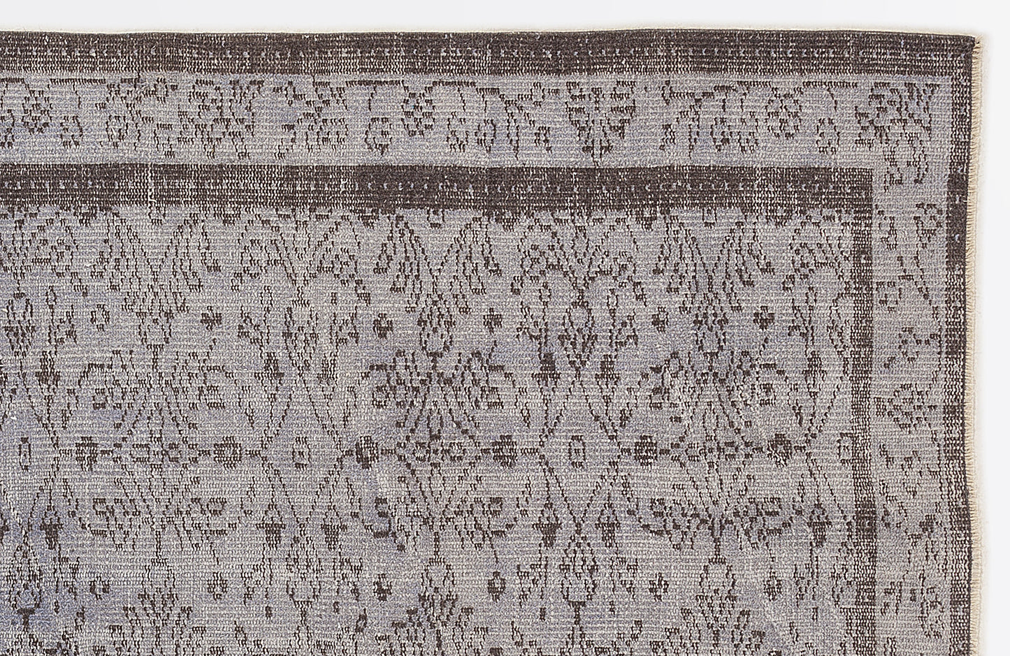 Charcoal and light gray rug with a distressed traditional floral medallion pattern and a bordered edge.