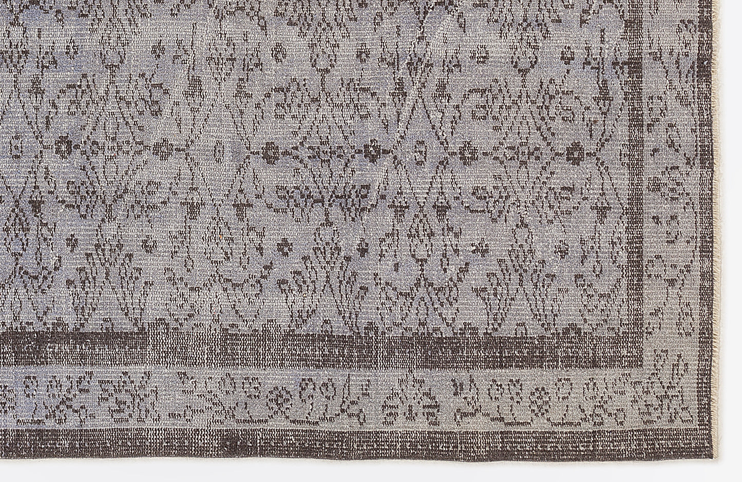 Grey and charcoal rug with a distressed traditional floral medallion pattern and a wide decorative border.