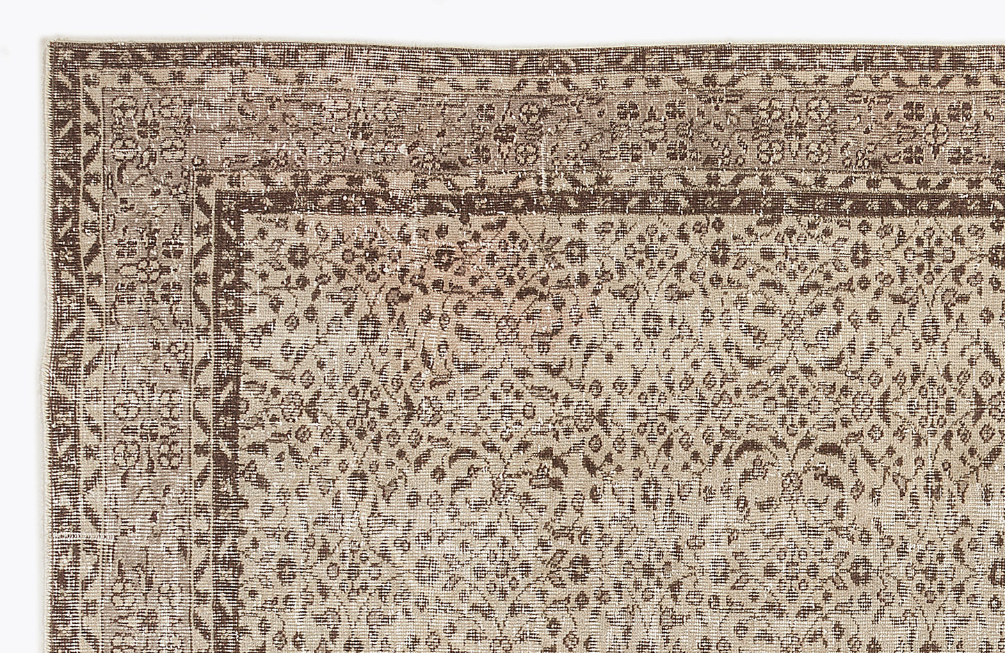 Beige and brown vintage-style rug with a distressed floral medallion pattern and a detailed geometric border.