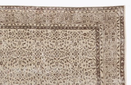 Load image 1 in gallery view. Beige and brown distressed rug with a traditional floral pattern and a geometric border.
