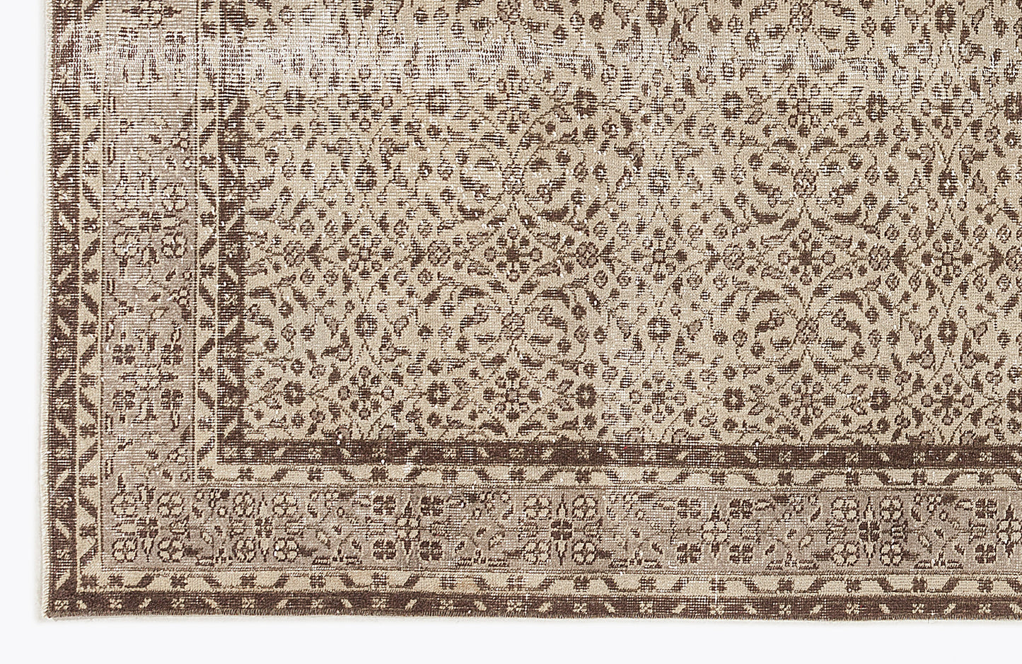 Taupe and dark brown rug with a distressed, intricate floral medallion pattern and a geometric border.