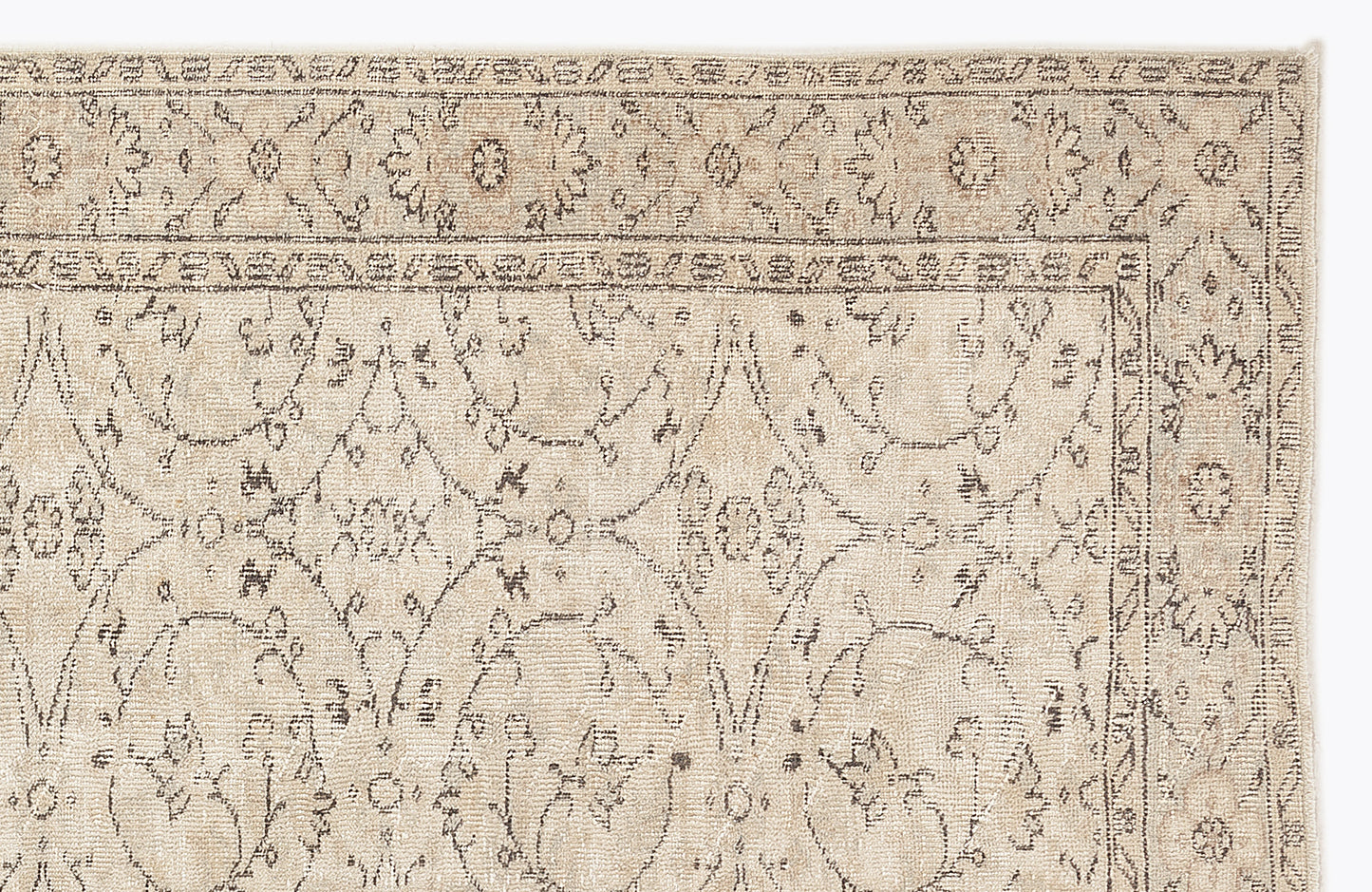 Beige rug with a dark grey traditional floral medallion pattern and a detailed border on a white background.