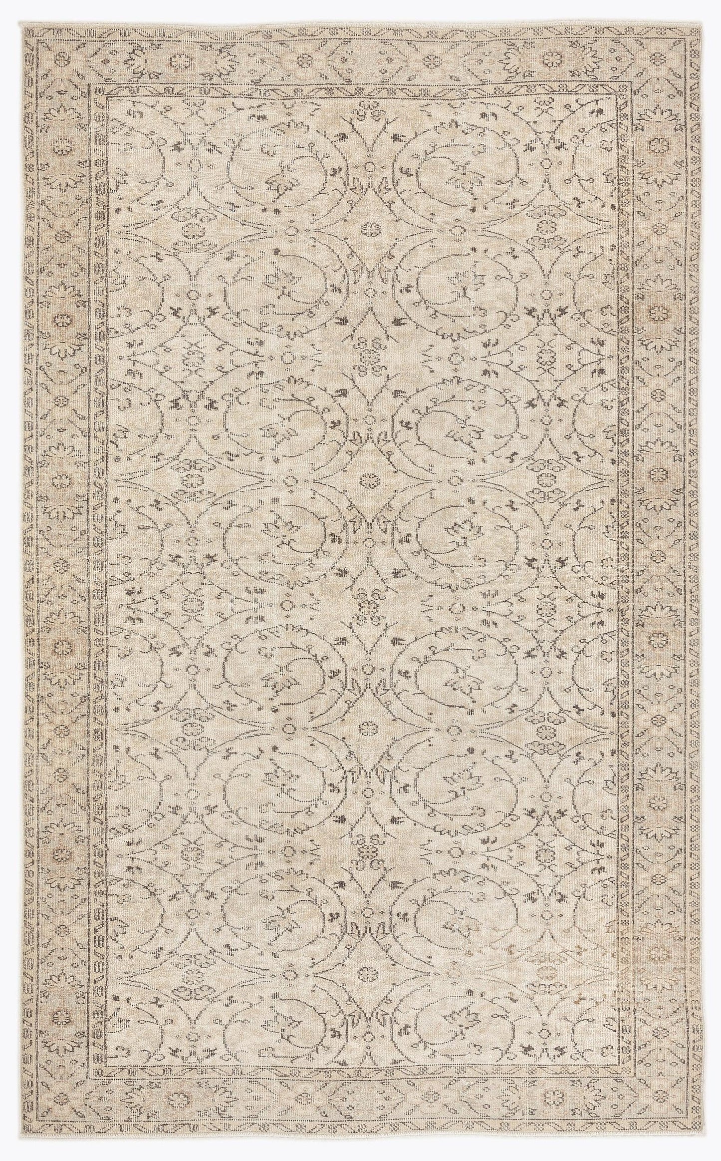 Beige and charcoal grey area rug with a repeating floral medallion pattern and a decorative border.