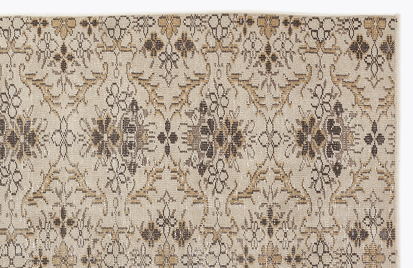 Beige rug with a repeating dark brown and tan floral medallion pattern in a distressed, vintage style.