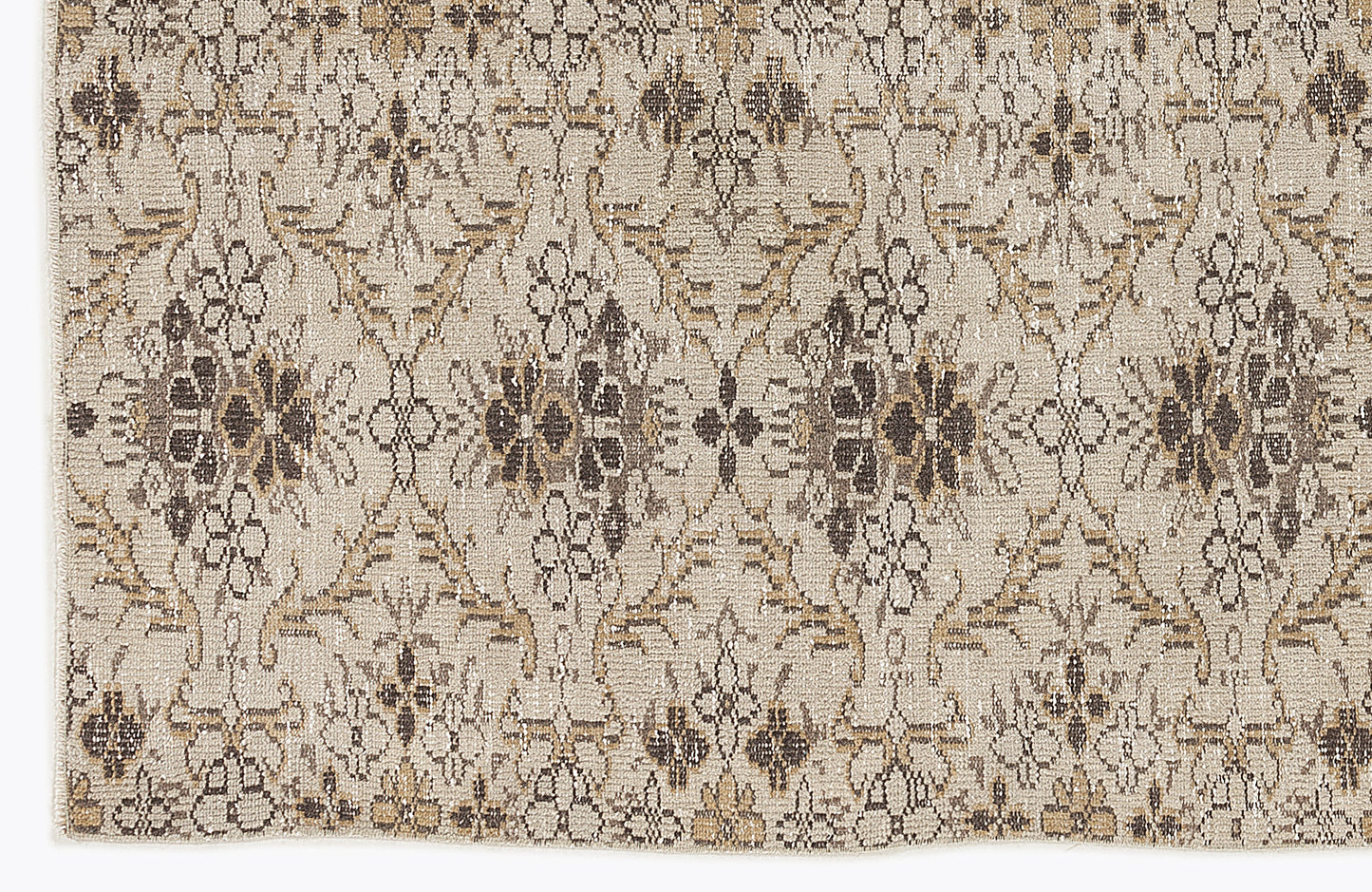 Beige and brown rug with a distressed, repeating floral medallion pattern.