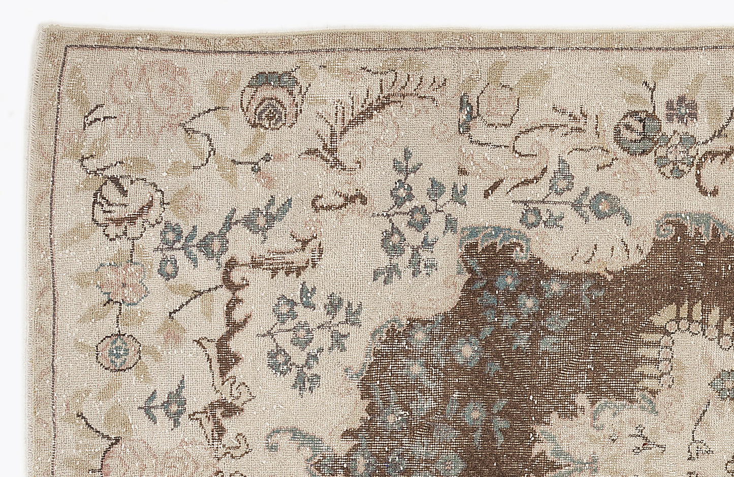 Beige vintage-style rug with a distressed floral pattern in muted brown, blue, and pink tones.