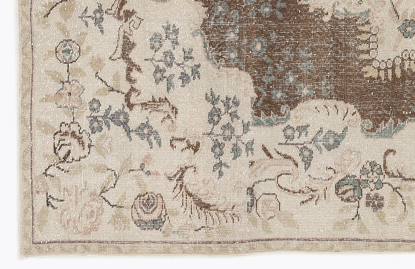 Beige rug with a distressed floral pattern in brown, muted blue, and soft pink.