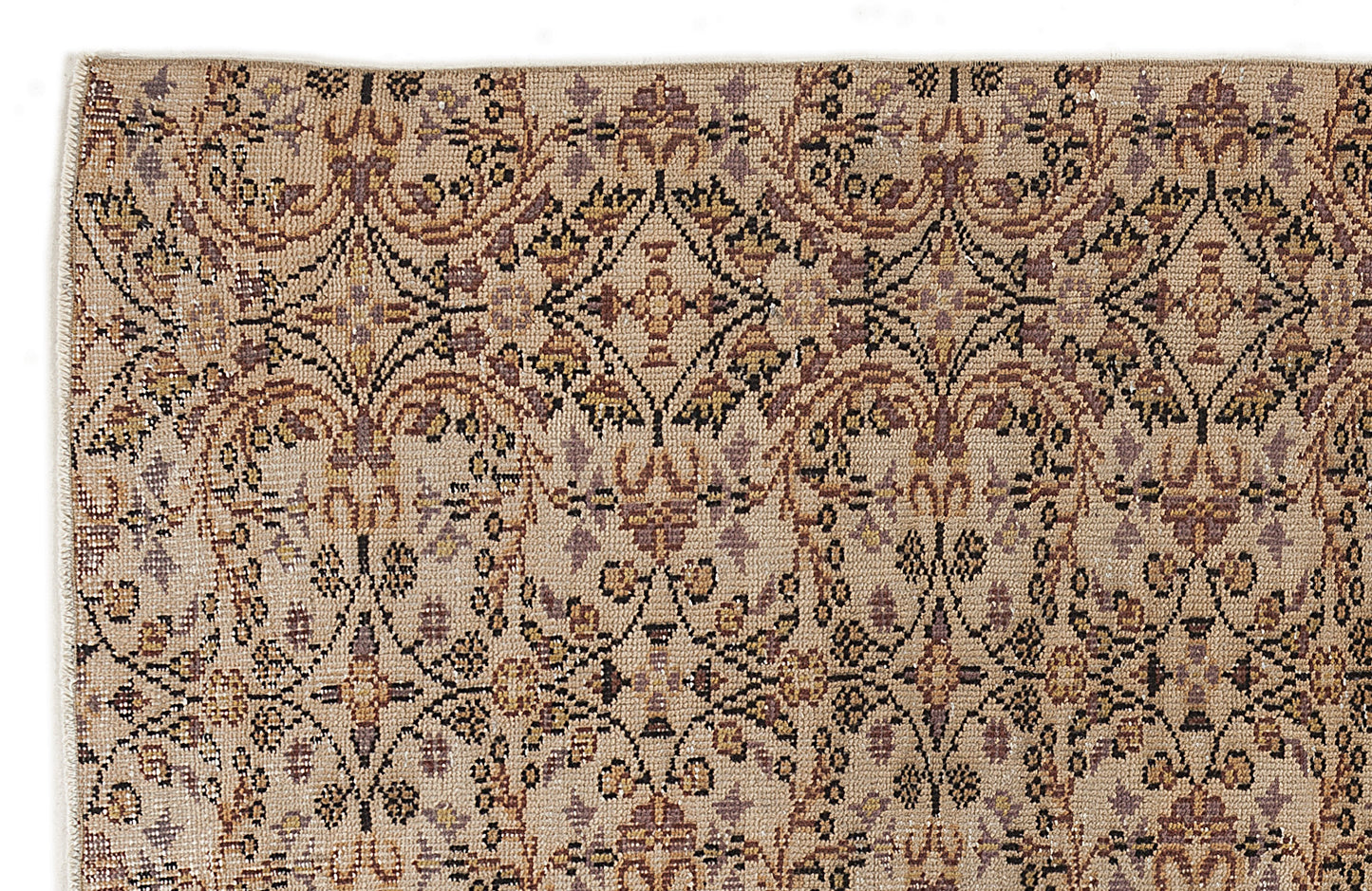 Beige rug with a repeating brown and muted purple floral medallion pattern on a white background.