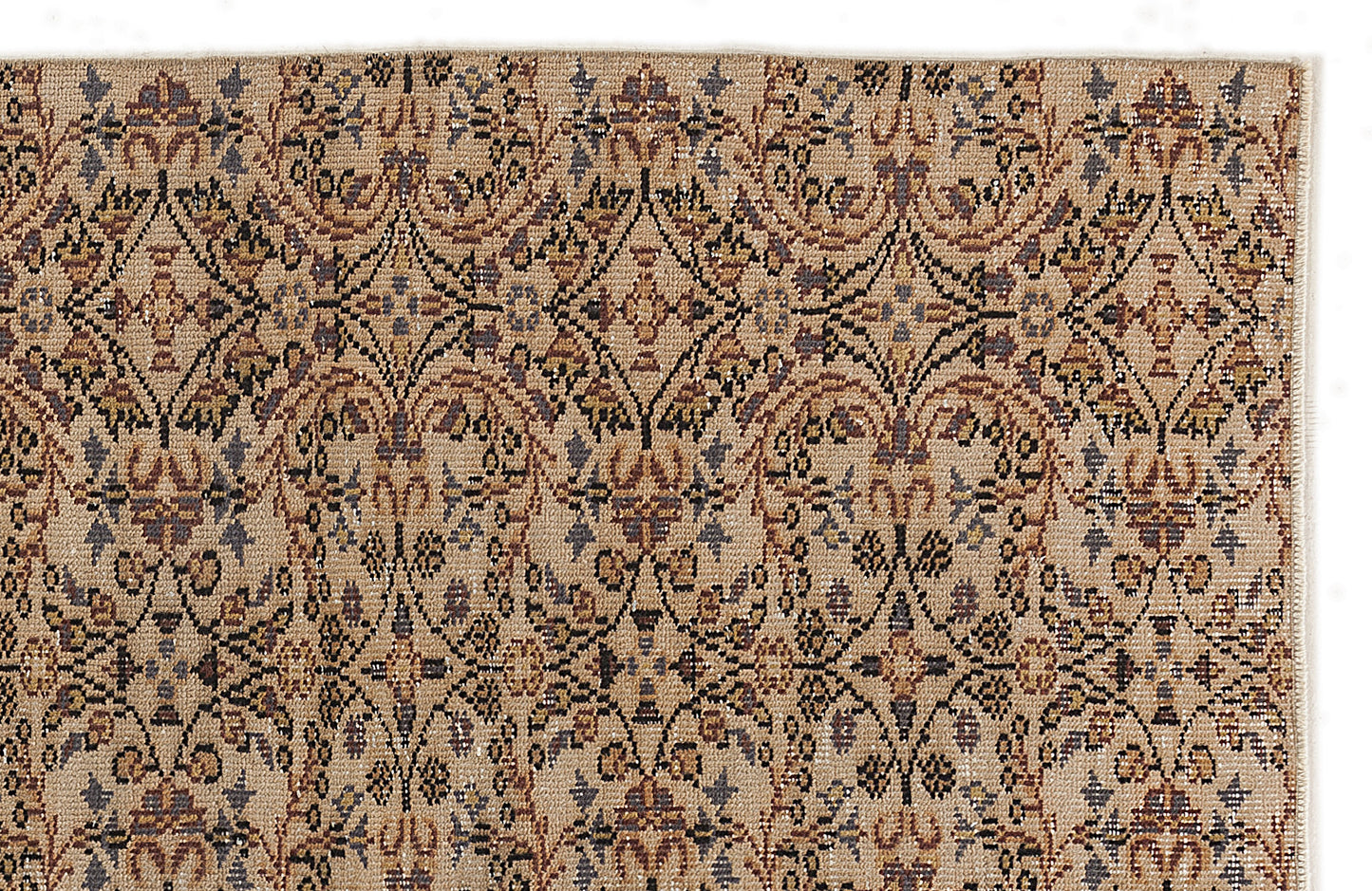 Tan rug with a repeating geometric floral medallion pattern in shades of brown, charcoal, and muted blue.