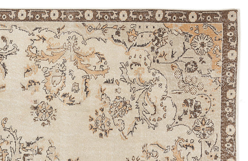 Load image 1 in gallery view. Beige and brown rug with a distressed floral medallion pattern and a dark brown geometric border.