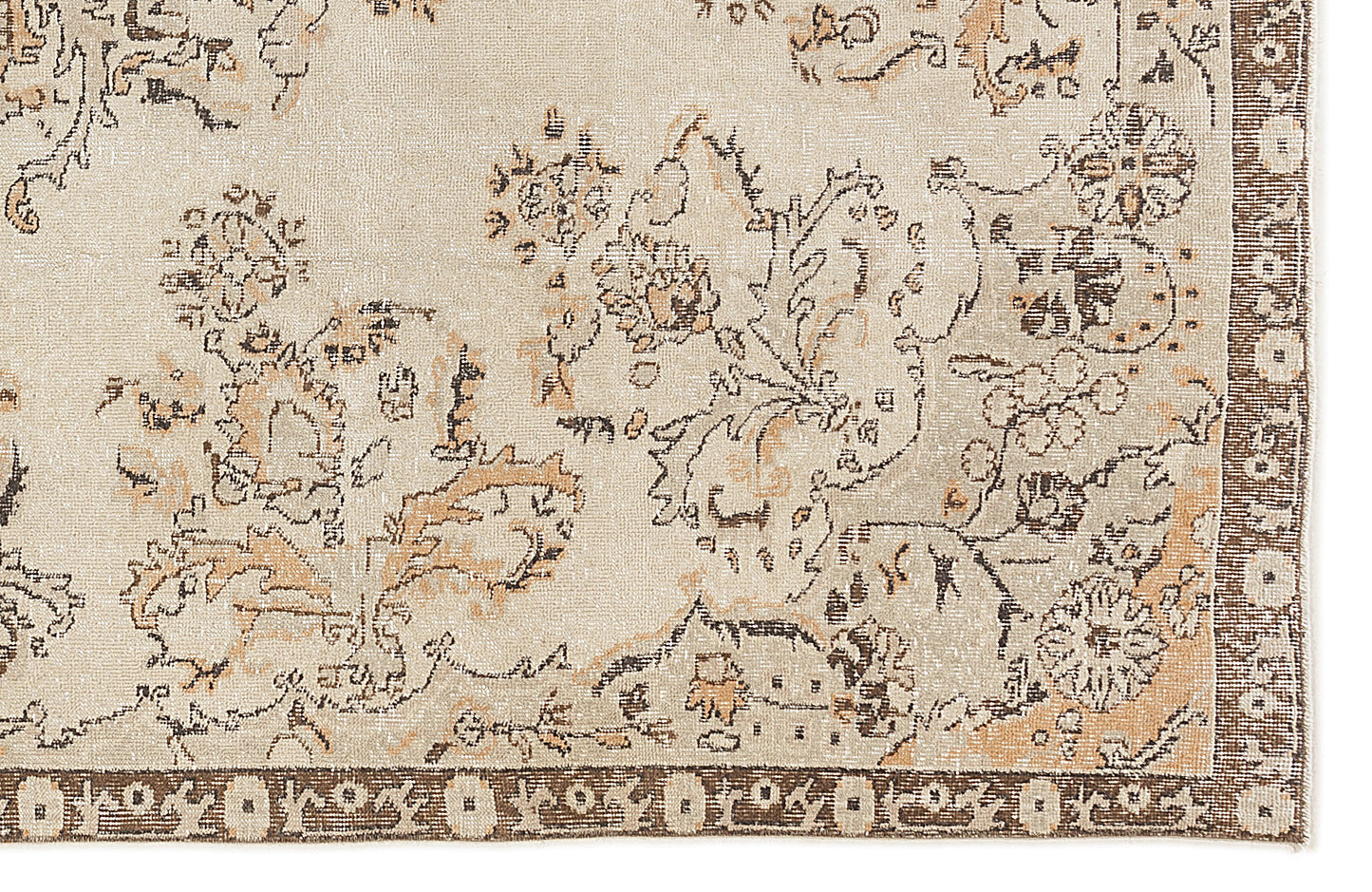 Beige and tan rug with a distressed floral pattern and a dark brown geometric border.
