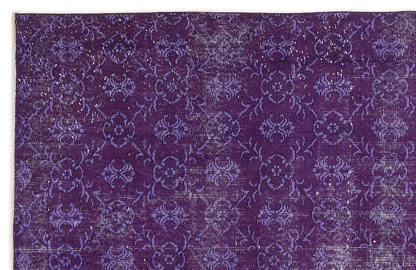 Deep purple rug with a distressed, repeating floral medallion pattern and white woven texture.