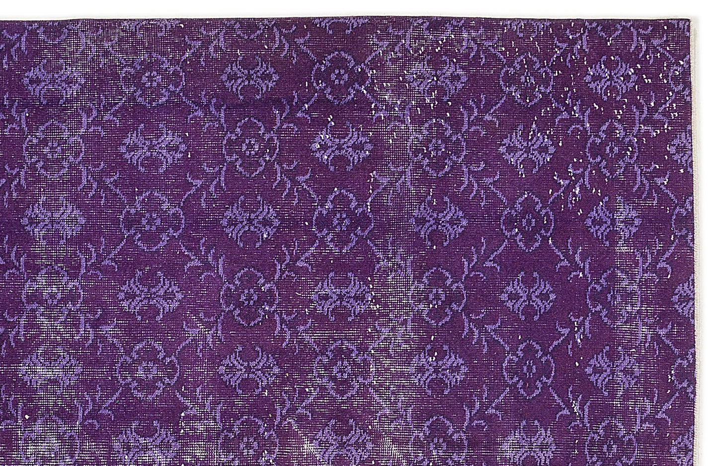 Deep purple rug with a repeating distressed floral medallion pattern on a white background.