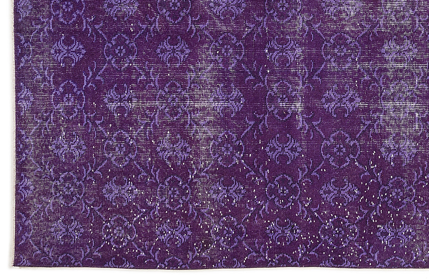 Deep purple rug with a distressed, repeating floral medallion pattern and white woven texture.