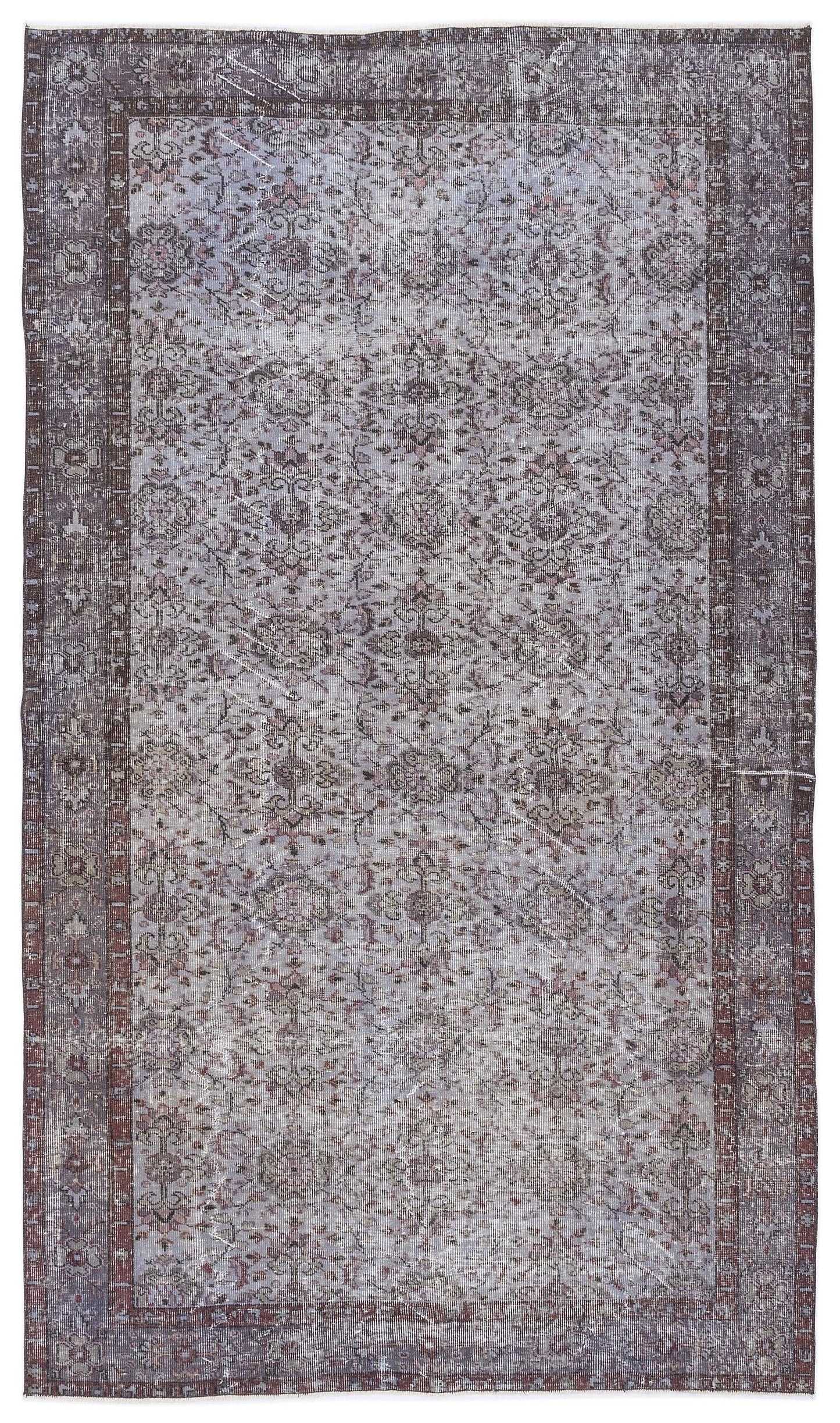 Distressed grey and dark brown rug with a traditional floral medallion pattern and a wide decorative border.