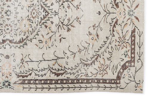 Load image 1 in gallery view. Beige and brown vintage-style rug with a distressed floral medallion pattern and a geometric border.