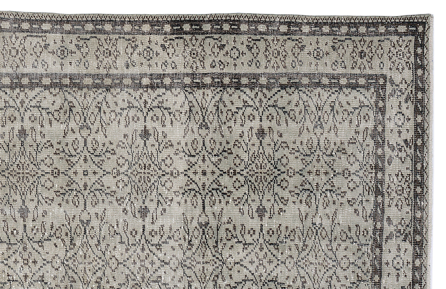 Grey and charcoal distressed rug with a traditional floral medallion pattern and a geometric border.