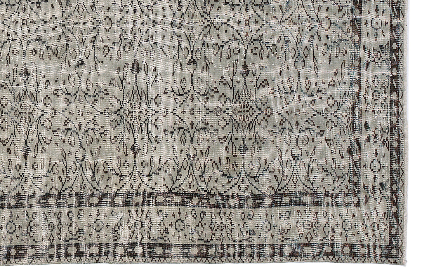 Grey and charcoal distressed rug with a traditional floral medallion pattern and a detailed geometric border.
