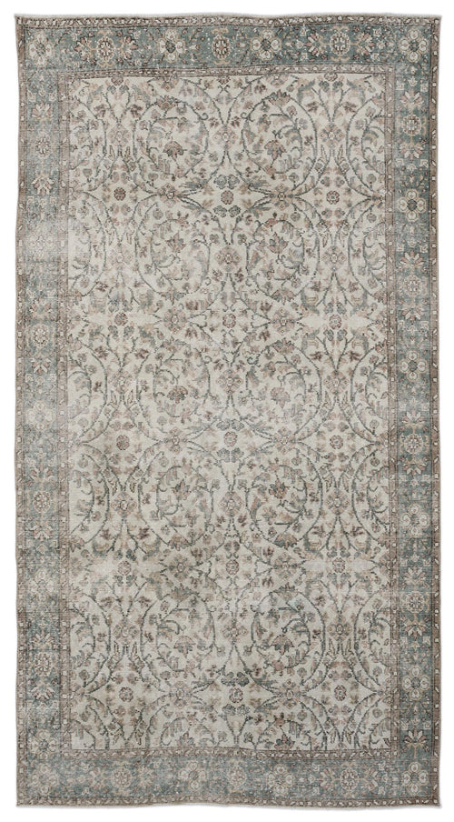 Load image 1 in gallery view. Distressed beige and sage green rug with a traditional floral medallion pattern and a wide decorative border.