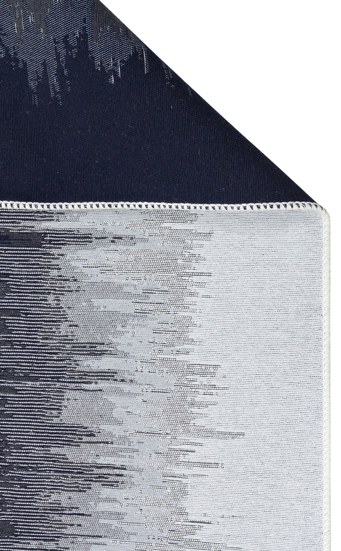 Close-up of the Charcoal Frame - Washable Double-Sided Kilims - AR40: features black and white abstract patterns, neat stitching on the edge, and a dark navy blue underside.