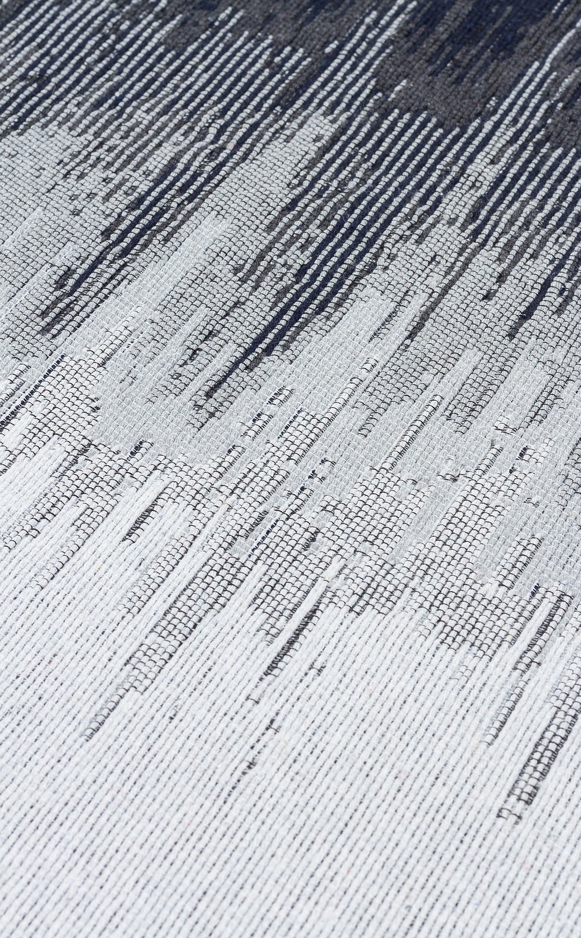 Close-up of the Charcoal Frame - Washable Double-Sided Kilims - AR40 rug, featuring a textured recycled cotton surface with an abstract linear pattern in white, gray, and dark blue that creates a striking diagonal gradient effect.