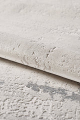 A close-up of the Abstract Blitz Premium Rug - Silver (M658D) shows its light, textured surface with a raised, irregular pattern and subtle shade variations that enhance its soft, plush feel.