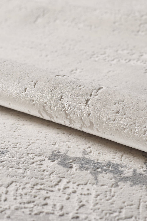 Load image 1 in gallery view. A close-up of the Abstract Blitz Premium Rug - Silver (M658D) shows its light, textured surface with a raised, irregular pattern and subtle shade variations that enhance its soft, plush feel.