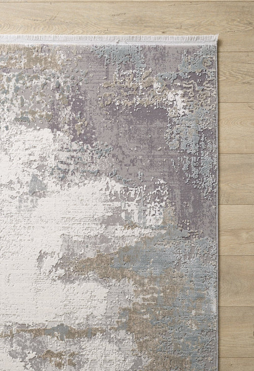 Load image 1 in gallery view. The Abstract Blitz Premium Rug - Silver - M658D, a modern machine-made rug with an abstract gray, white, beige, and pale blue pattern, features subtle texture and short fringe on one edge for a contemporary look atop the light wooden floor.