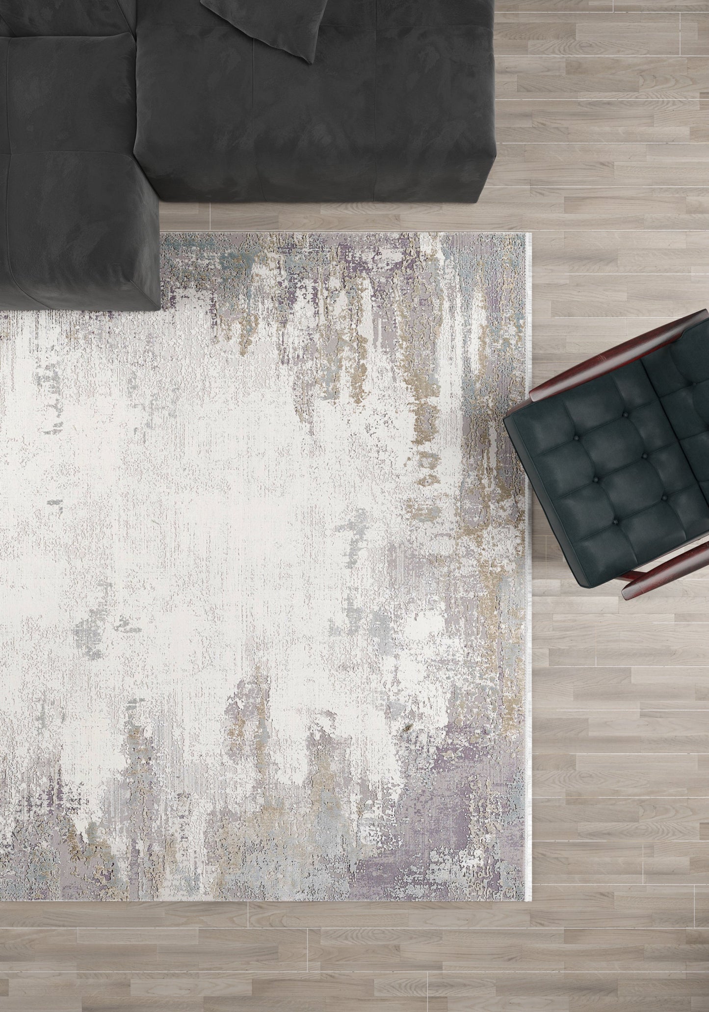 A top-down view of a modern living room with the Abstract Blitz Premium Rug - Silver (M658D), a dark gray sectional sofa in the top left, and a black cushioned chair with wooden arms on the right, all on a light wood floor.