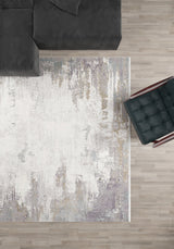 A top-down view of a modern living room with the Abstract Blitz Premium Rug - Silver (M658D), a dark gray sectional sofa in the top left, and a black cushioned chair with wooden arms on the right, all on a light wood floor.