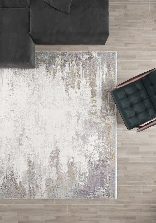 Load image 1 in gallery view. A top-down view of a modern living room with the Abstract Blitz Premium Rug - Silver (M658D), a dark gray sectional sofa in the top left, and a black cushioned chair with wooden arms on the right, all on a light wood floor.