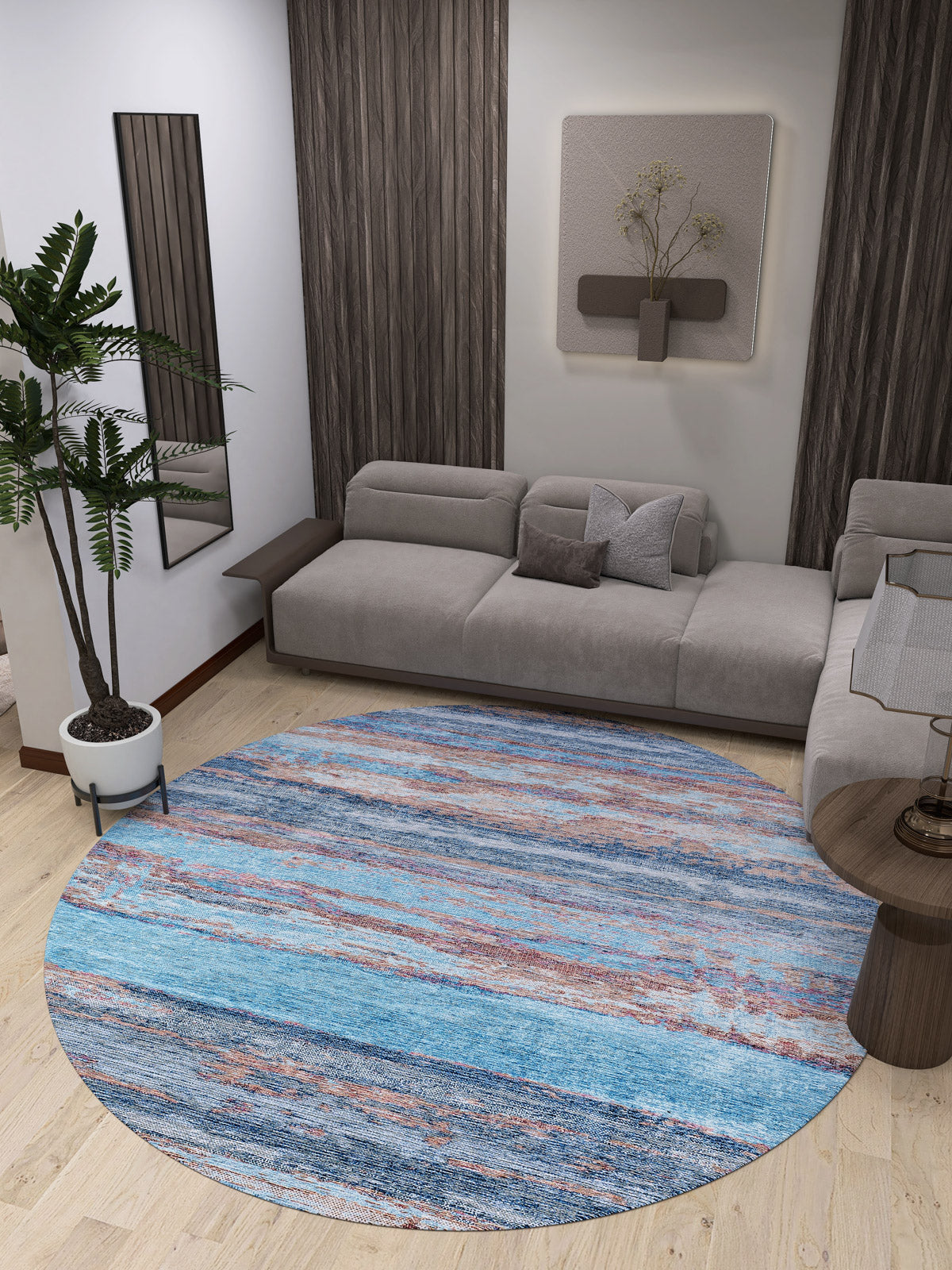 Modern living room with a gray sectional, Abstract Elegance - Machine-Washable Rug JR87 (Custom Size) in blue for high-traffic areas, potted plant, wall art, mirror, wood accents on walls and side tables, and light wood floors.