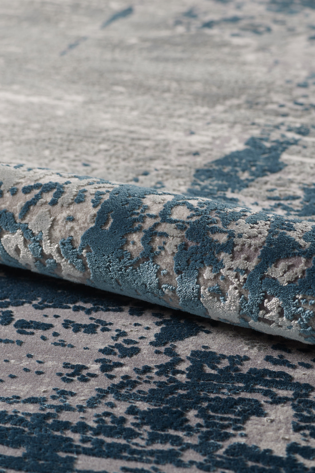 Close-up of the Abstracta Blue Premium Rug - 1004F, showcasing its textured blue and gray pattern, soft fibers, and slightly raised abstract design.