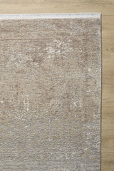 The Abstracta Creme Premium Rug - 1004B, featuring a textured abstract pattern in beige and gray, lies on a light wood floor. Only part of this modern acrylic-viscose rug is visible in the image.