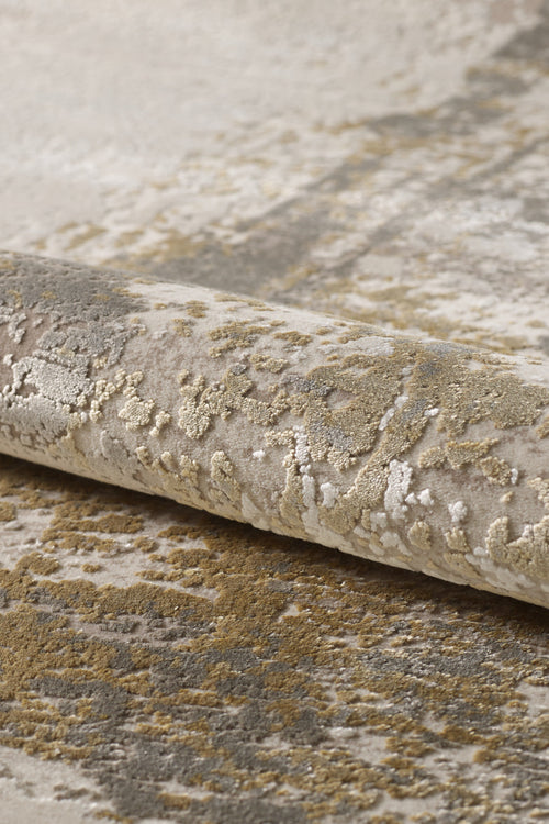 Load image 1 in gallery view. A close-up of the Abstracta Gold Premium Rug - 1004G showcases its plush, textured pattern in beige, gold, and gray with varied pile heights—a stunning machine-made piece for any modern space.