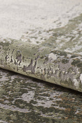 Close-up of the Abstracta Green Premium Rug - 1004H, machine-made and rolled up to showcase its textured pattern in green, gray, and cream tones, evoking a natural or abstract landscape.