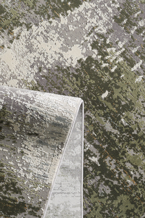 Load image 1 in gallery view. A close-up of the Abstracta Green Premium Rug - 1004H shows its abstract mottled green, gray, and cream pattern; one corner is folded to display the reverse side.