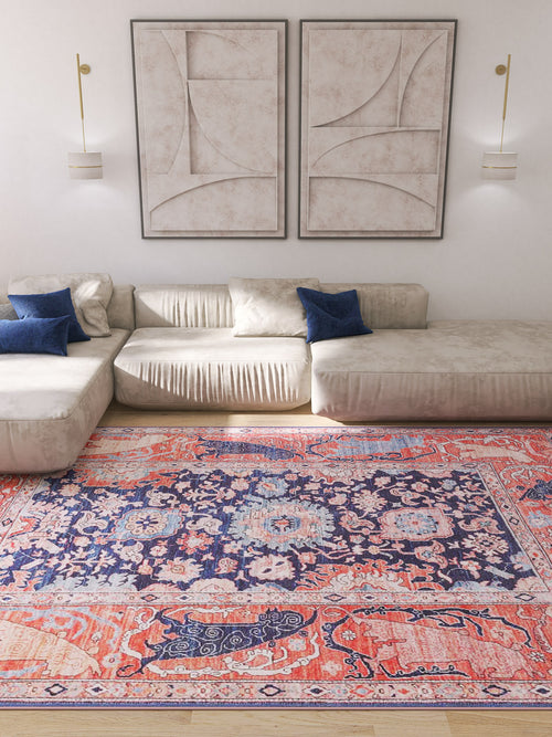 Load image 1 in gallery view. A modern living room featuring light beige sofas, blue accent pillows, abstract wall art, wall-mounted lights, and the Aegis Handmade-Design Washable Rug - LCC3029 (Custom Size) with vibrant red, blue, and pink patterns on the wooden floor.