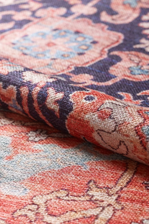 Load image 1 in gallery view. A close-up of the Aegis Handmade-Design Washable Rug - LCC3029 (Custom Size), rolled to highlight its fine texture and detailed red, blue, pink, and cream patterns—an ideal choice for allergy-sensitive homes.