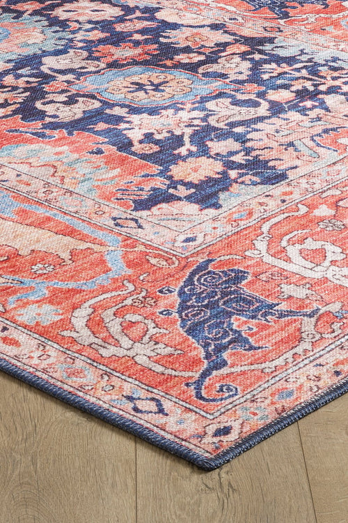 Load image 1 in gallery view. A close-up of the Aegis Handmade-Design Washable Rug - LCC3029 (Custom Size) featuring ornate floral and geometric patterns in coral, navy blue, ivory, and light blue on a wooden floor—perfect for high-traffic areas.