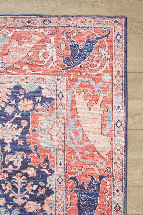 Load image 1 in gallery view. A close-up of the Aegis Handmade-Design Washable Rug - LCC3029 (Custom Size), featuring intricate pink, blue, cream, and coral patterns, ideal for allergy-sensitive homes and high-traffic areas on a light brown wood floor.